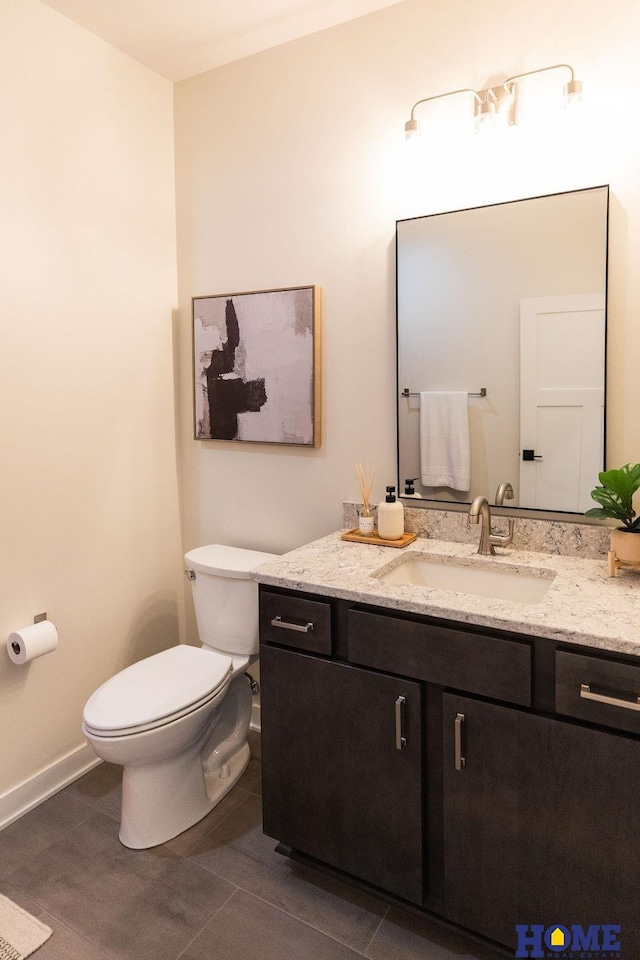 bathroom featuring toilet, vanity, and tile patterned flooring