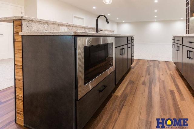 kitchen featuring sink, black microwave, and dark hardwood / wood-style flooring