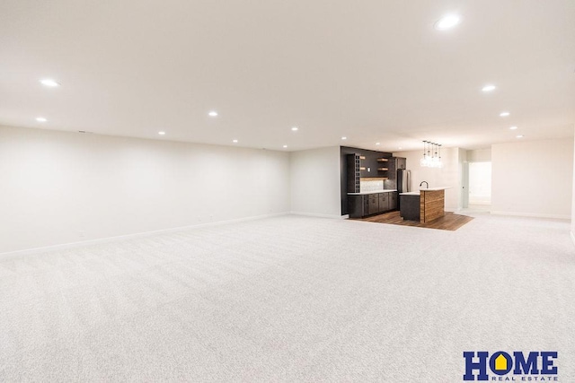 basement with stainless steel refrigerator, light carpet, and indoor bar