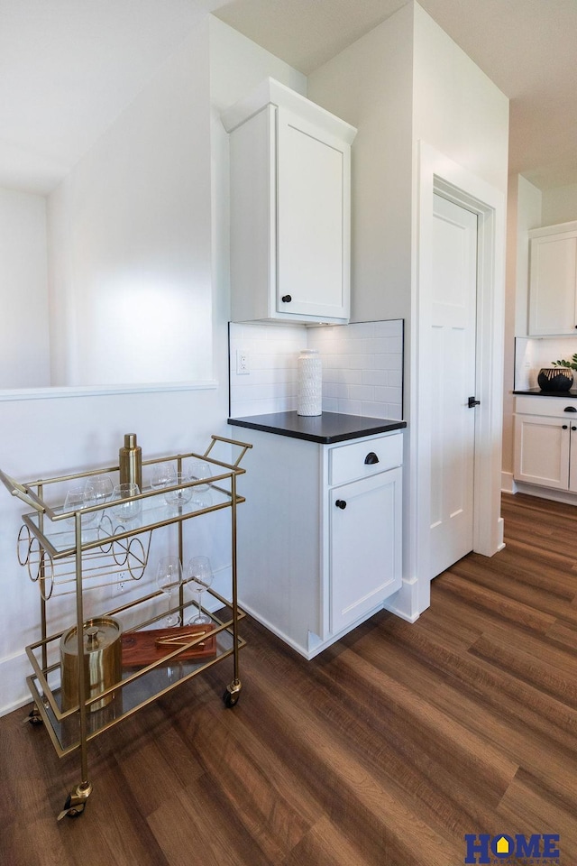 interior space featuring decorative backsplash, white cabinetry, and dark hardwood / wood-style floors