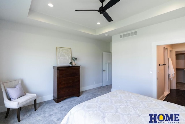 bedroom featuring ceiling fan, carpet, and a tray ceiling