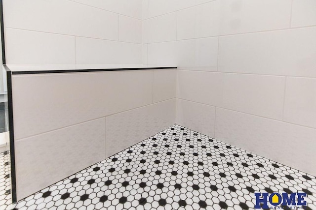 interior details featuring a tile shower