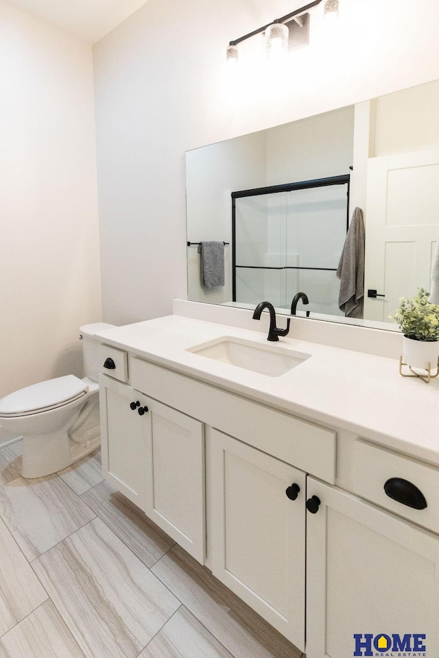 bathroom with a shower with door, toilet, and vanity