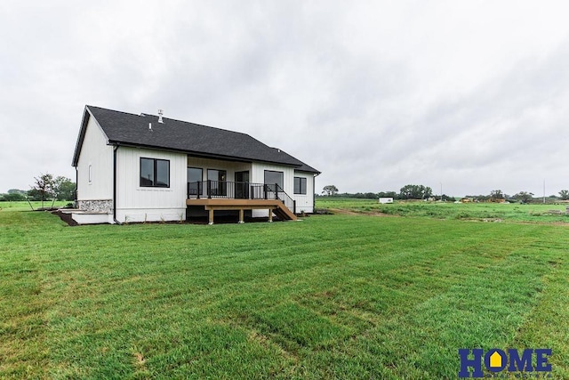 rear view of property with a deck and a yard