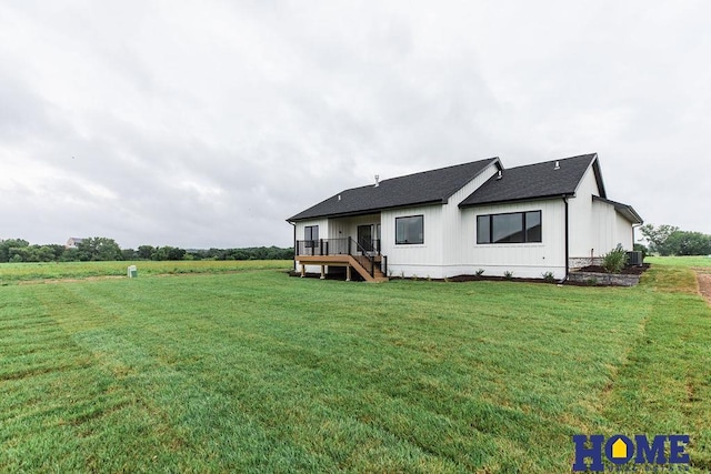 back of house featuring a lawn and a wooden deck