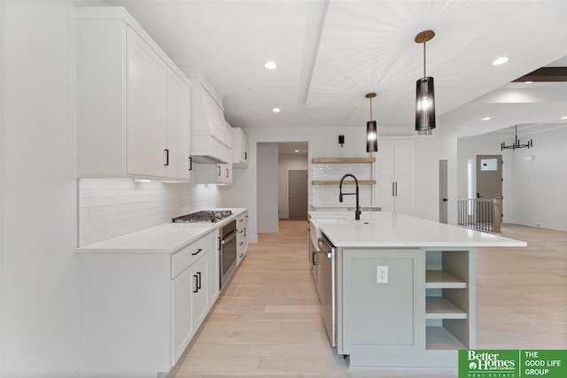 kitchen featuring white cabinetry, a large island, stainless steel appliances, and hanging light fixtures