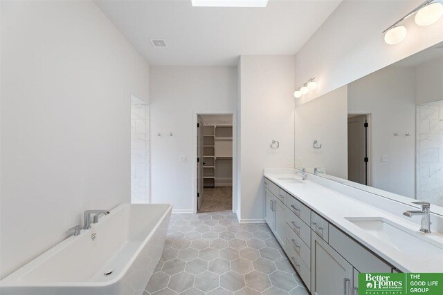 bathroom featuring a bathing tub, tile patterned flooring, and vanity