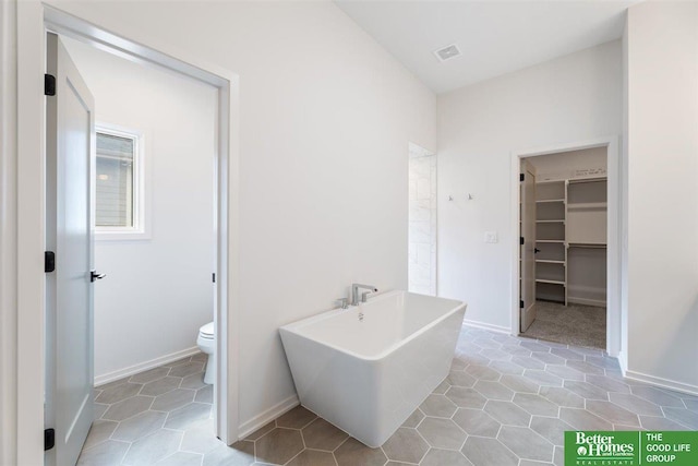 bathroom with tile patterned floors, toilet, and a bathing tub