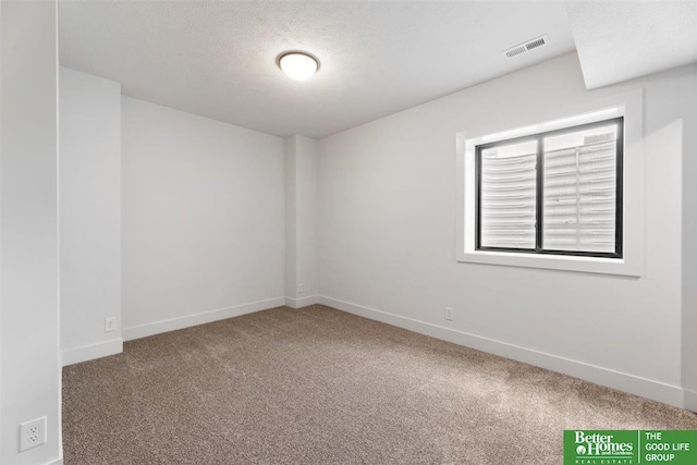 unfurnished room featuring a textured ceiling and carpet