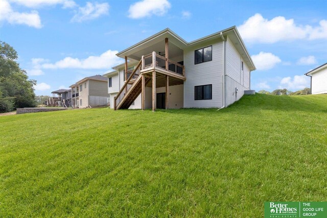 back of house with a wooden deck and a yard