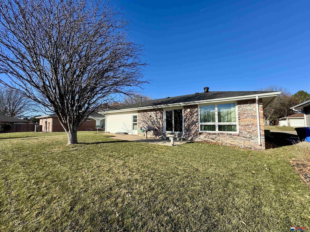 back of property with a lawn and a patio