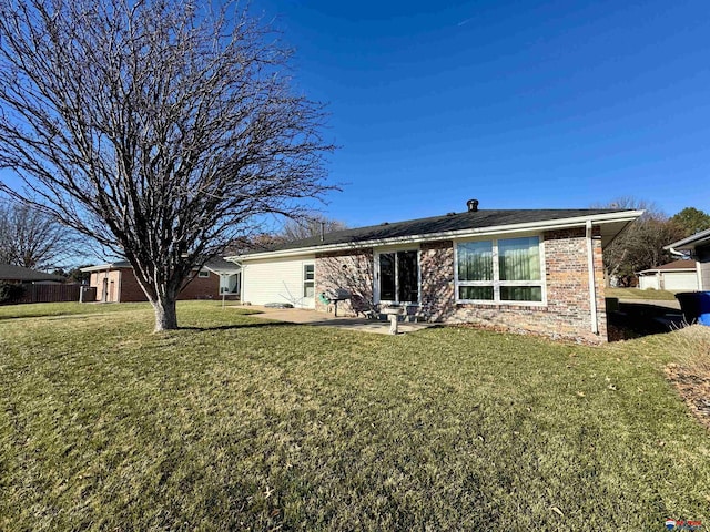 back of property with a lawn and a patio