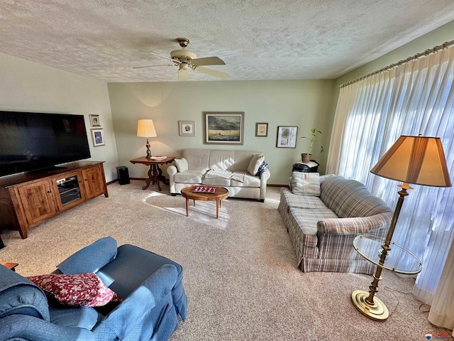 carpeted living room featuring ceiling fan and a textured ceiling