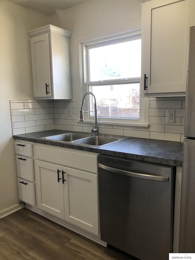 kitchen featuring appliances with stainless steel finishes, white cabinetry, sink, backsplash, and dark hardwood / wood-style floors