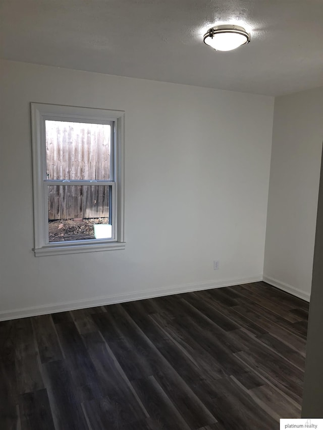 unfurnished room featuring dark wood-type flooring and a textured ceiling