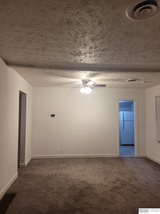 carpeted empty room with ceiling fan and a textured ceiling