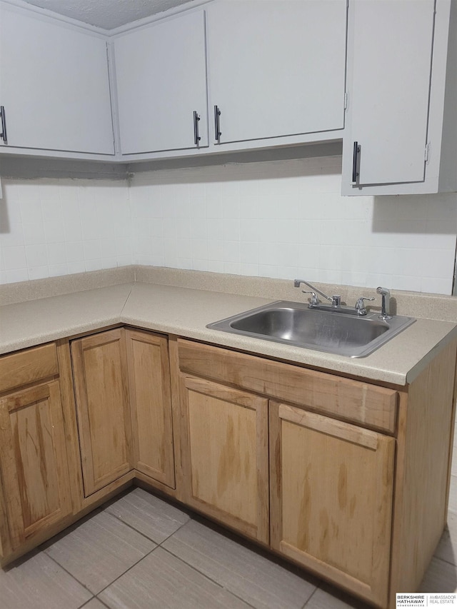 kitchen with sink, white cabinetry, and light tile patterned flooring