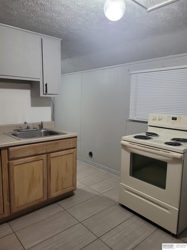 kitchen featuring sink, a textured ceiling, white electric range oven, and wooden walls