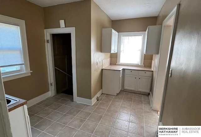 kitchen featuring light tile patterned floors and white cabinets