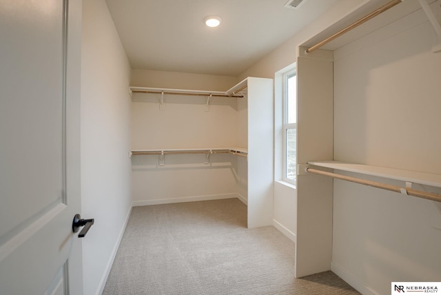 walk in closet featuring light carpet