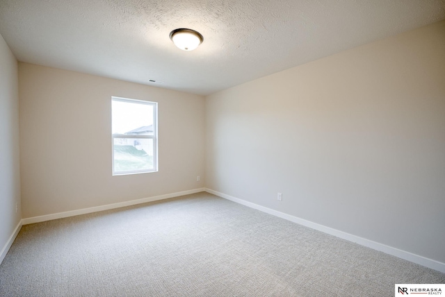 carpeted spare room featuring a textured ceiling