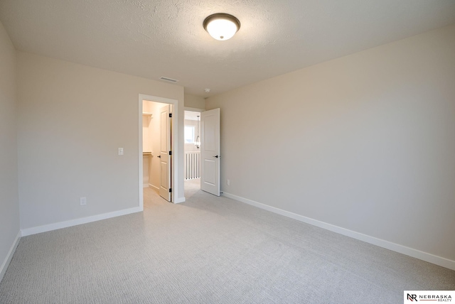 unfurnished room with a textured ceiling