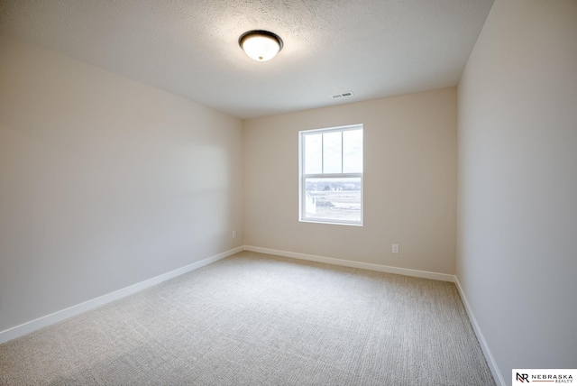 carpeted spare room with a textured ceiling