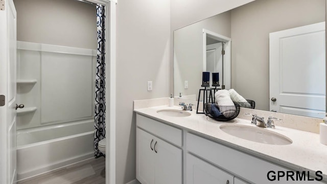 full bathroom featuring toilet, vanity, wood-type flooring, and shower / tub combo