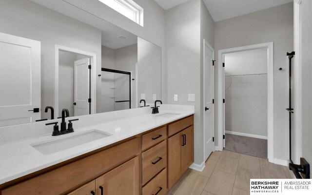 bathroom with an enclosed shower, vanity, and tile patterned flooring