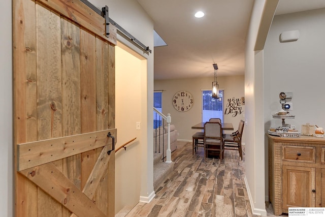 hall with hardwood / wood-style flooring and a barn door