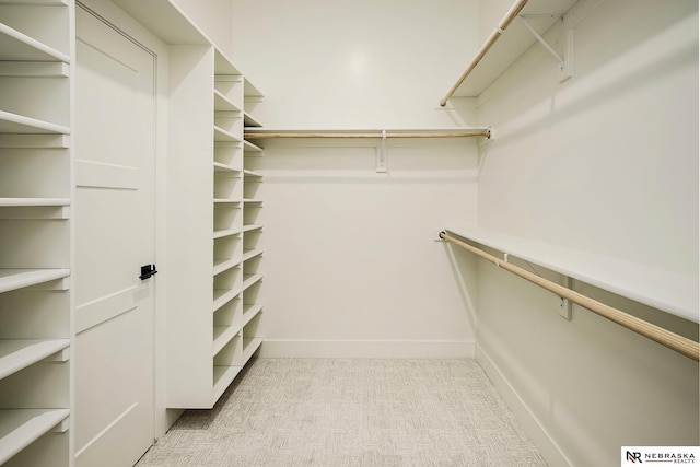 walk in closet featuring light colored carpet