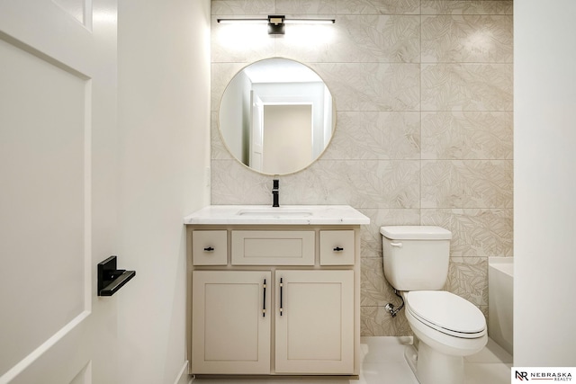 bathroom with a tub, tile walls, toilet, and vanity