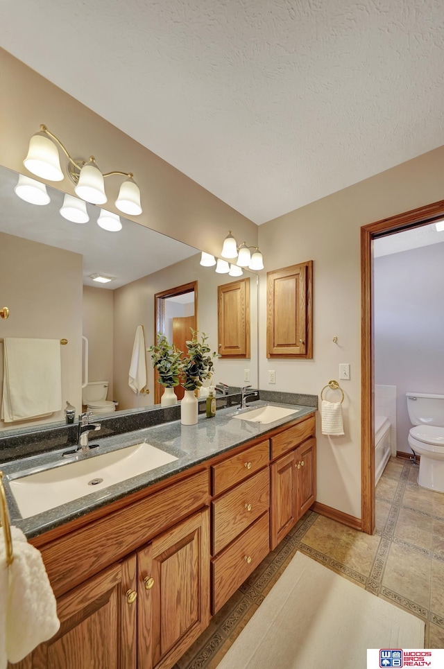 bathroom with tile patterned flooring, a tub, a textured ceiling, toilet, and vanity