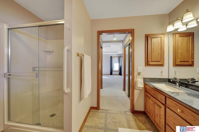 bathroom featuring vanity and a shower with door