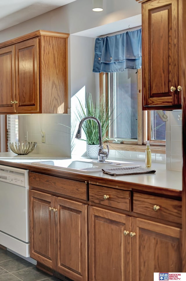 kitchen featuring sink, a healthy amount of sunlight, decorative backsplash, and white dishwasher