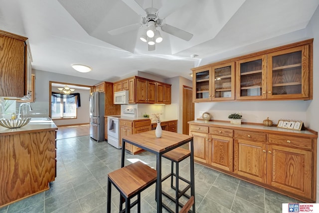 kitchen featuring ceiling fan, sink, and white appliances