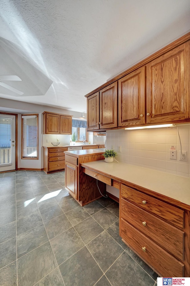 kitchen with ceiling fan, a textured ceiling, and tasteful backsplash