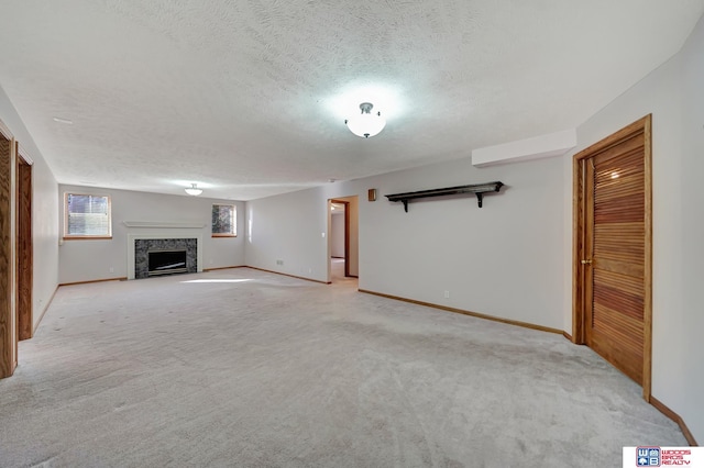 unfurnished living room with light colored carpet and a textured ceiling