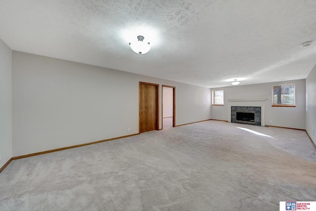 unfurnished living room with light carpet, a textured ceiling, and a fireplace