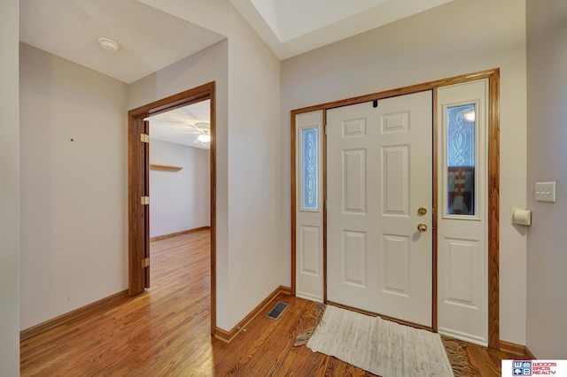 foyer with vaulted ceiling and light hardwood / wood-style floors