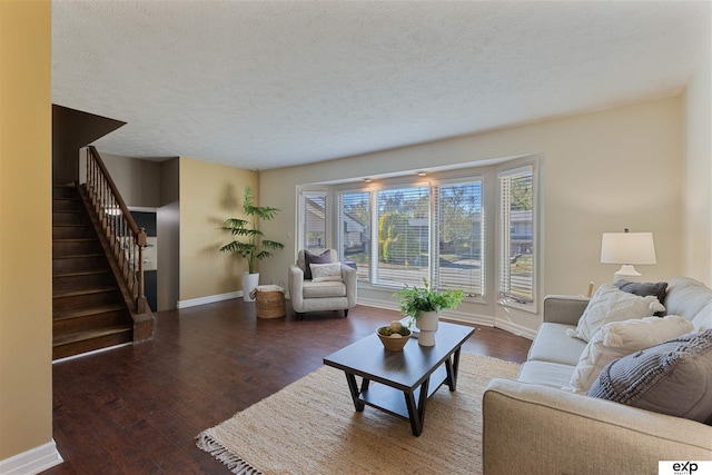 living room with dark hardwood / wood-style floors and a textured ceiling