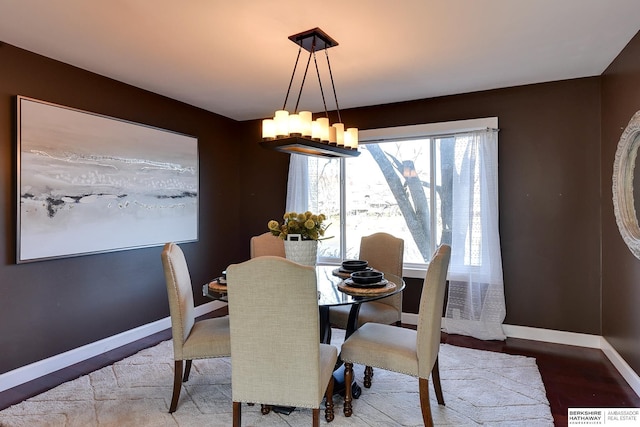 dining room with hardwood / wood-style floors and a notable chandelier