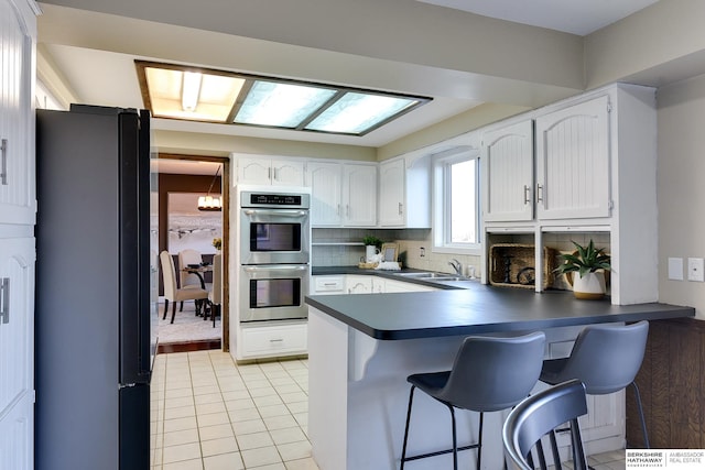 kitchen with sink, white cabinets, refrigerator, and stainless steel double oven