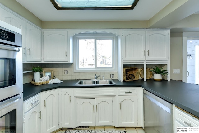 kitchen featuring sink, white cabinetry, appliances with stainless steel finishes, and tasteful backsplash