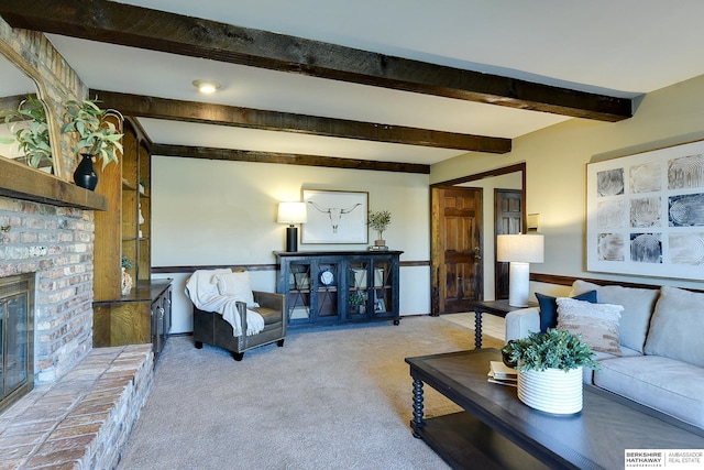 carpeted living room featuring beamed ceiling and a fireplace