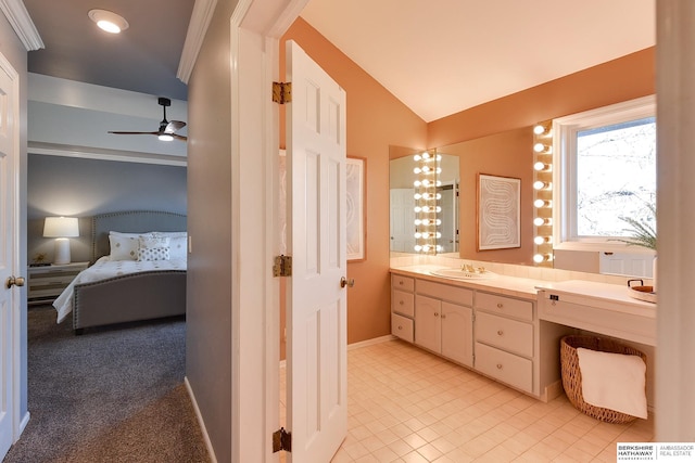 bathroom featuring ceiling fan, lofted ceiling, vanity, and ornamental molding