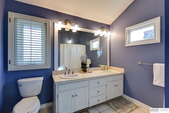 bathroom featuring tile patterned floors, vanity, toilet, and vaulted ceiling