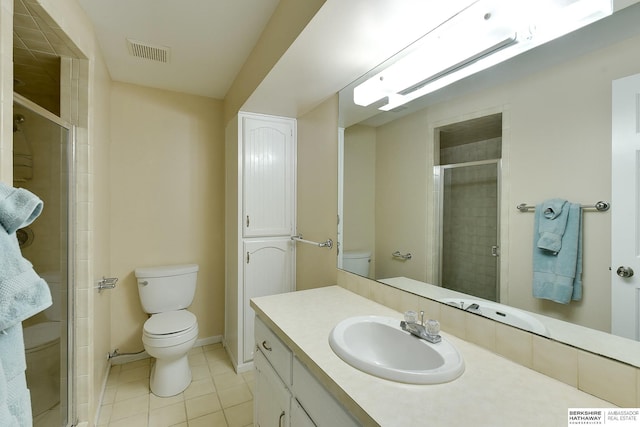 bathroom with a shower with shower door, tile patterned floors, vanity, and toilet