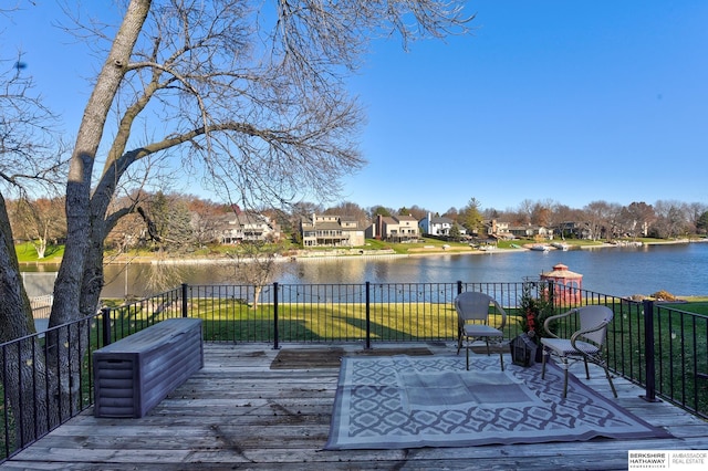 wooden deck featuring a lawn and a water view