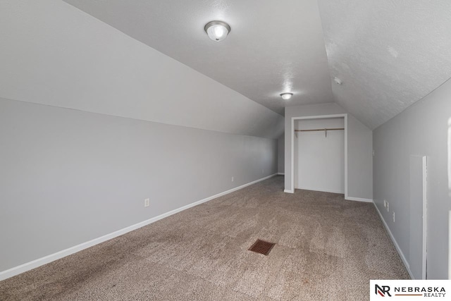 bonus room featuring a textured ceiling, carpet, and vaulted ceiling